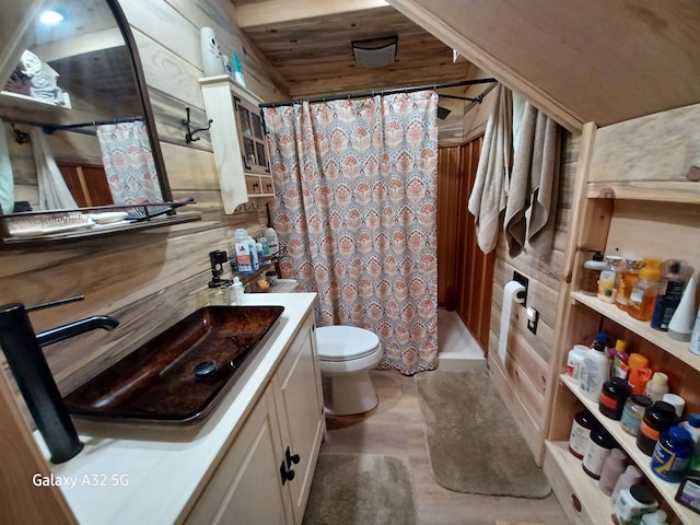 bathroom with curtained shower, toilet, vanity, and wood walls