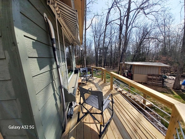 wooden terrace featuring an outbuilding and a shed