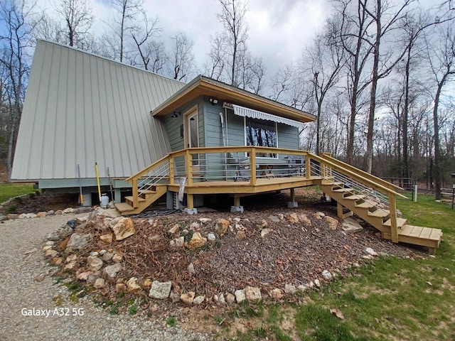 view of front of property with stairs, a wooden deck, and metal roof