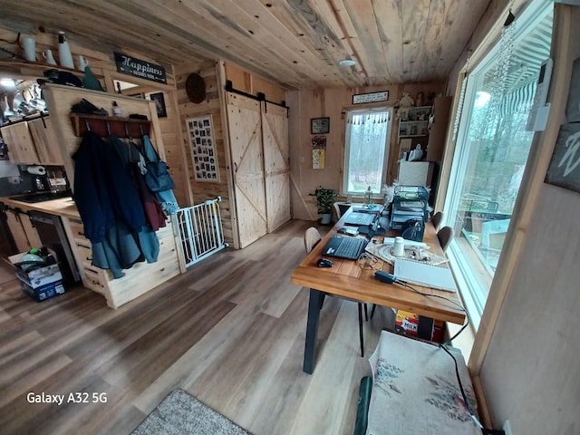 office featuring wooden ceiling, a barn door, and wood finished floors