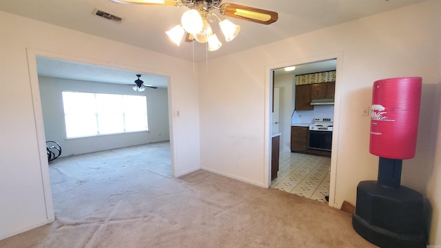 empty room with visible vents, baseboards, light colored carpet, and a ceiling fan