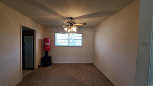 carpeted empty room with baseboards, a textured ceiling, and ceiling fan