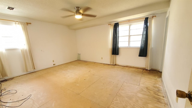 spare room with visible vents, a textured ceiling, and a ceiling fan