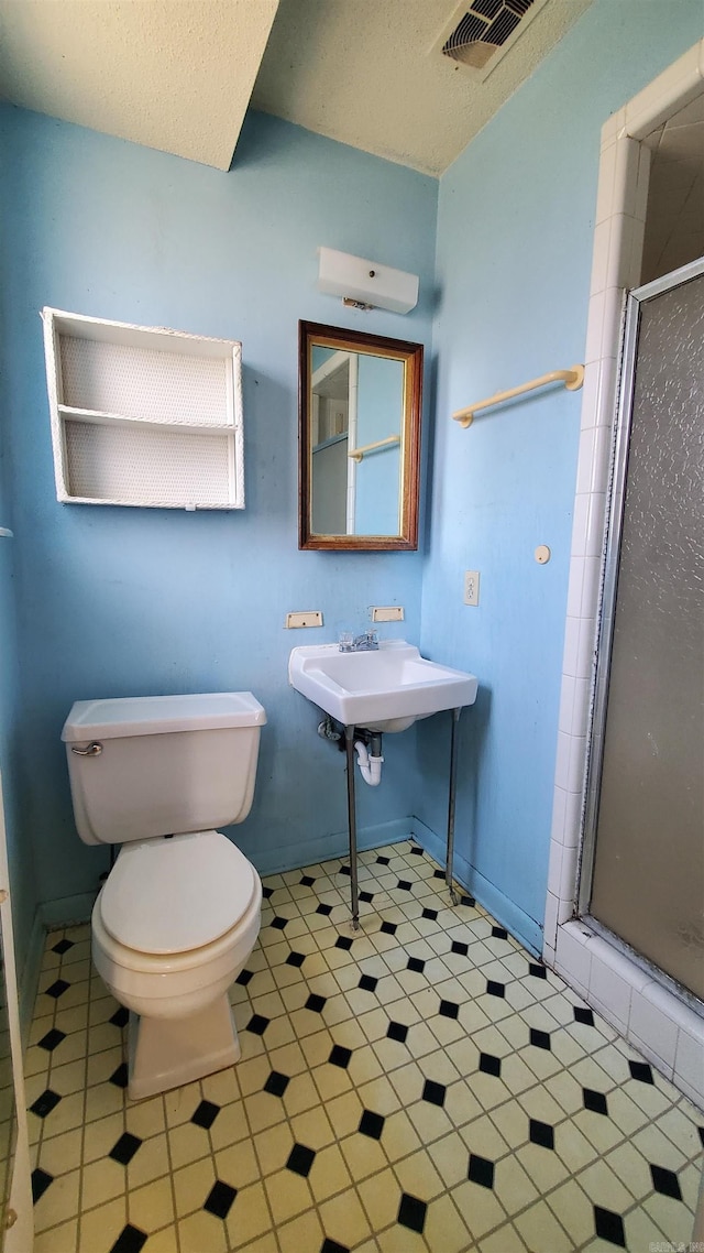 full bath with visible vents, toilet, a textured ceiling, a shower stall, and baseboards