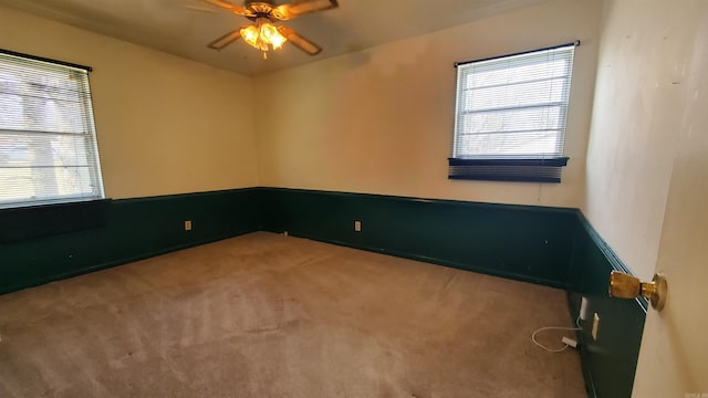 unfurnished room featuring carpet floors, a healthy amount of sunlight, and ceiling fan