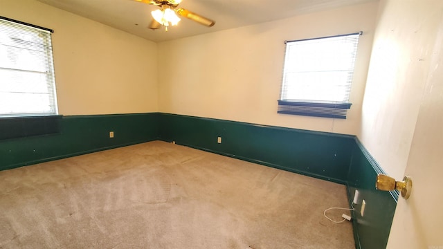 carpeted spare room with ceiling fan