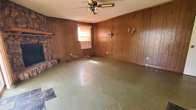 unfurnished living room featuring tile patterned floors, a fireplace, wood walls, and ceiling fan