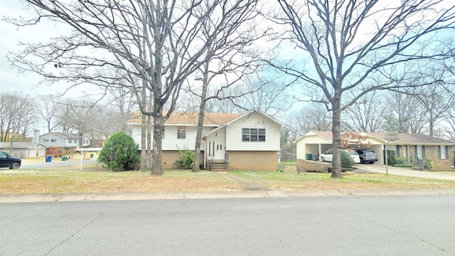 view of front of home with brick siding, a residential view, entry steps, a carport, and driveway