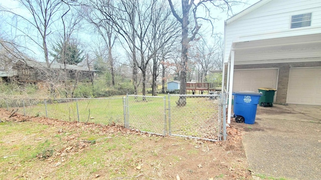 view of yard with a gate, a garage, and fence