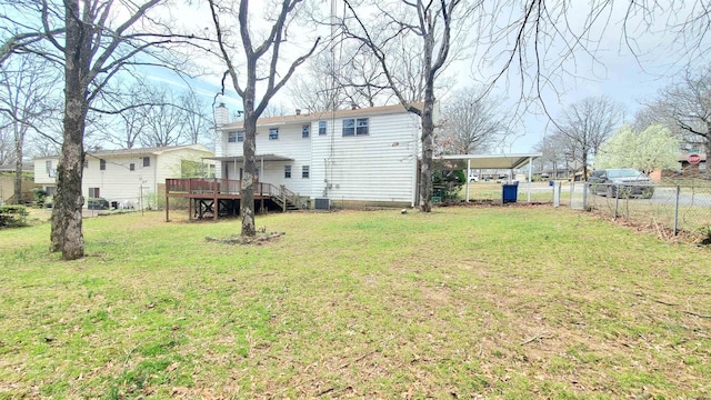 view of yard with a carport, central AC unit, fence, and a wooden deck