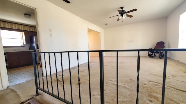 hallway featuring carpet flooring, an upstairs landing, and visible vents