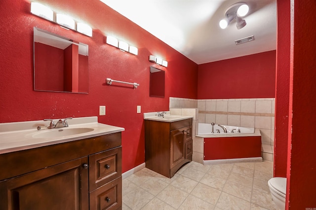 bathroom with a sink, visible vents, a garden tub, and two vanities