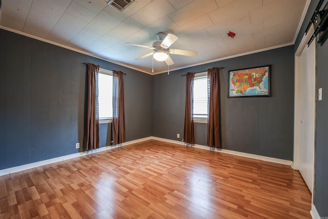 spare room featuring visible vents, light wood-type flooring, ceiling fan, and ornamental molding