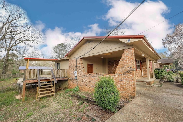 view of home's exterior with brick siding and a deck