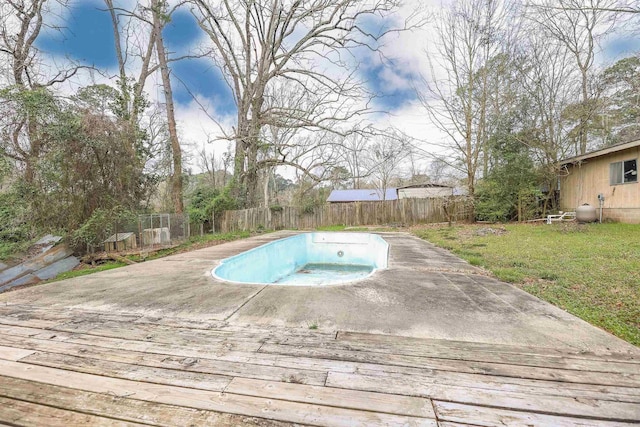 view of swimming pool featuring a yard, a fenced backyard, and a hot tub