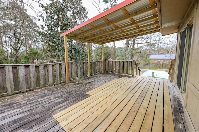 wooden deck featuring a swimming pool and fence
