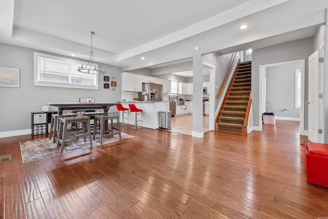 dining room with visible vents, baseboards, stairs, and light wood finished floors