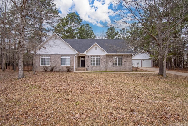 single story home featuring brick siding, a garage, concrete driveway, and an outdoor structure