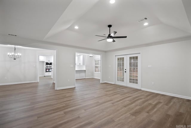 unfurnished living room featuring a raised ceiling, wood finished floors, and visible vents