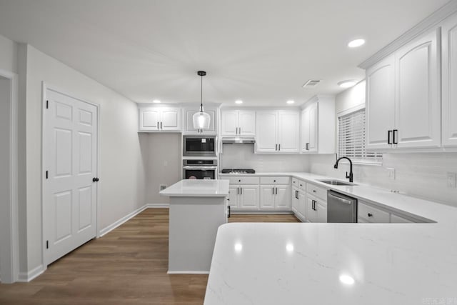 kitchen with a sink, white cabinets, tasteful backsplash, and stainless steel appliances