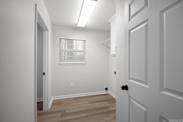 washroom with baseboards, cabinet space, hookup for an electric dryer, and wood finished floors