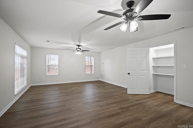 unfurnished living room featuring visible vents, baseboards, dark wood-style floors, and ceiling fan