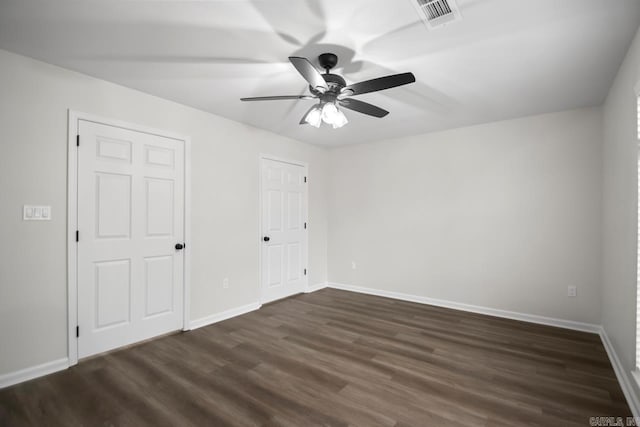 unfurnished bedroom featuring ceiling fan, dark wood-style floors, visible vents, and baseboards