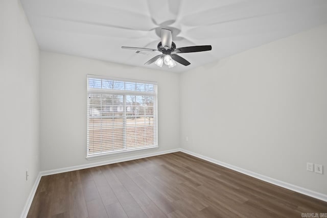 empty room featuring dark wood-type flooring, baseboards, and ceiling fan