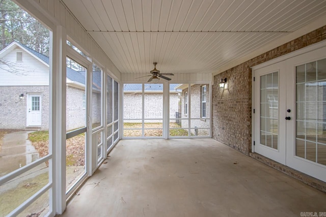 unfurnished sunroom with a ceiling fan and french doors