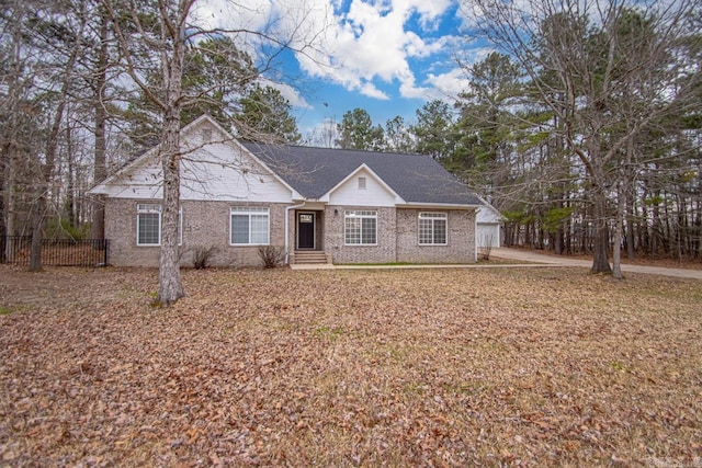 ranch-style house featuring brick siding and fence