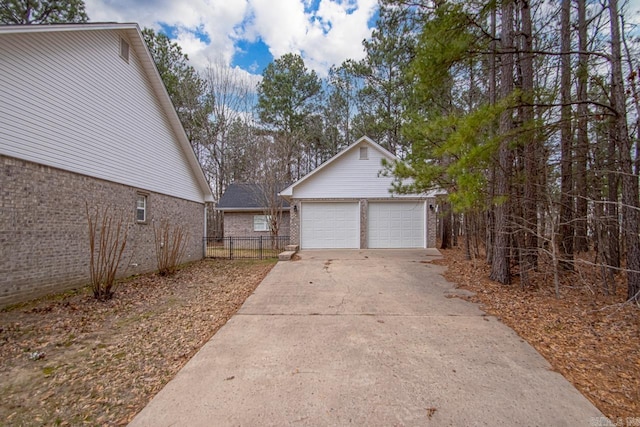 exterior space featuring concrete driveway and fence