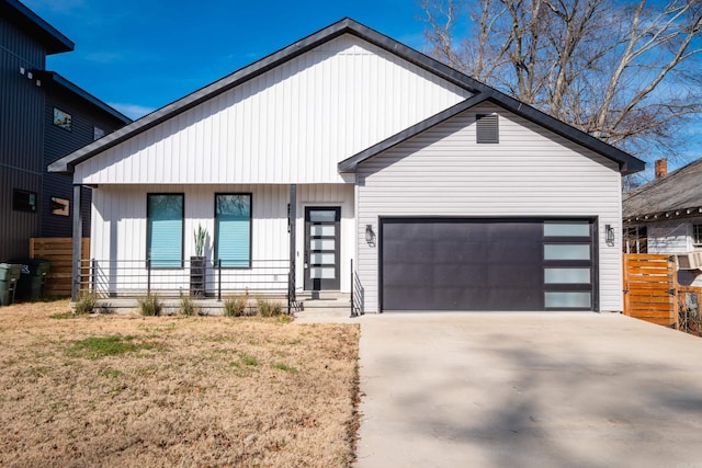 modern farmhouse style home featuring concrete driveway, an attached garage, a porch, and a front yard