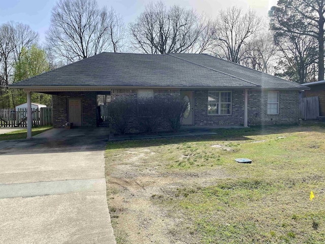 single story home with a front yard, a shingled roof, concrete driveway, a carport, and brick siding