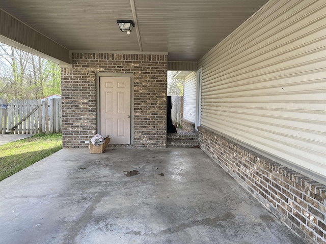 view of patio / terrace with an attached carport and fence