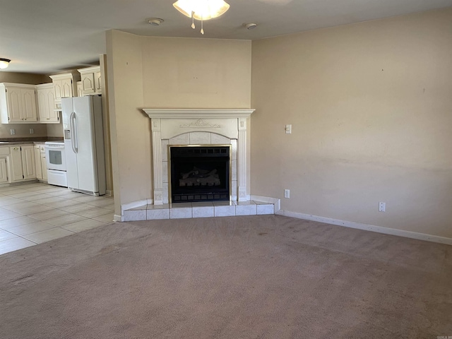 unfurnished living room featuring light carpet, light tile patterned floors, a tile fireplace, and baseboards