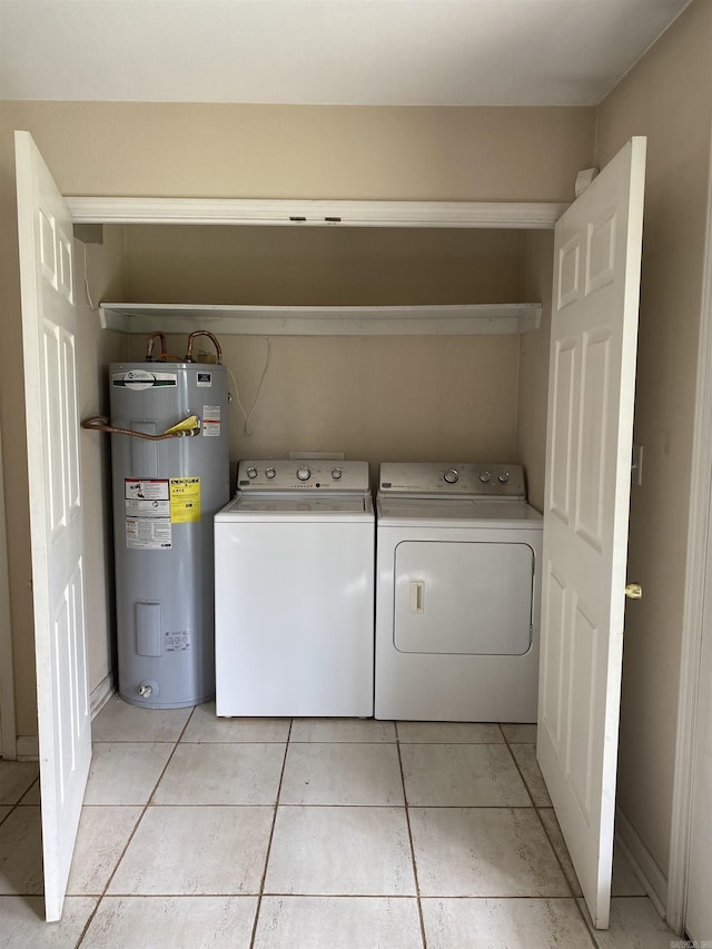 laundry room featuring laundry area, washing machine and clothes dryer, light tile patterned floors, and electric water heater