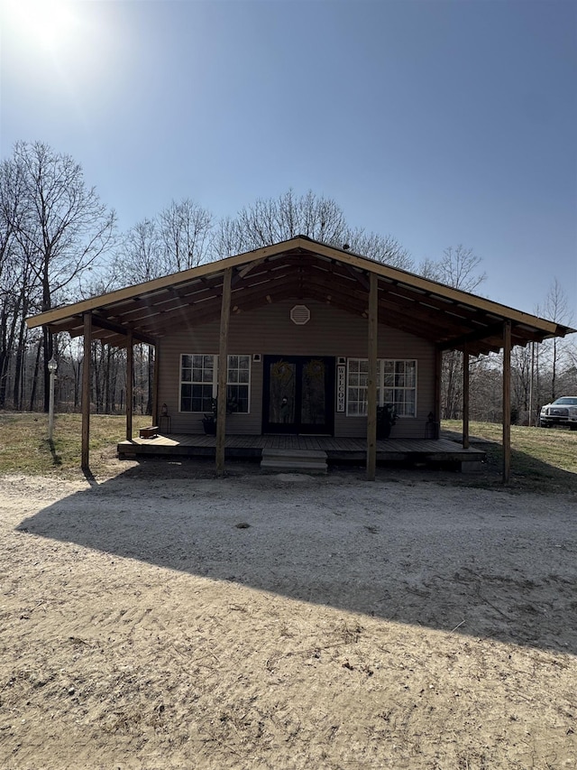 view of front of property featuring a carport and dirt driveway