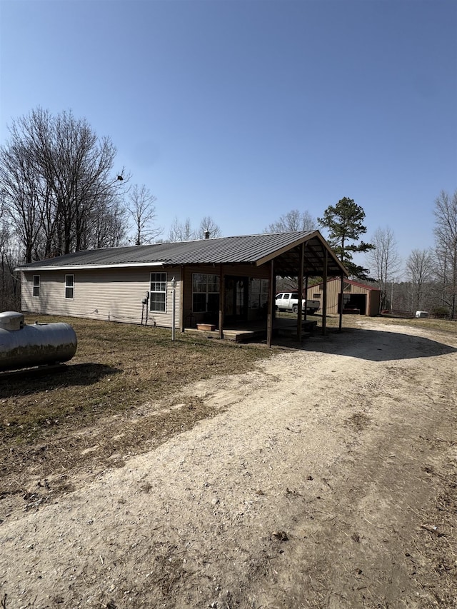 view of front of house with metal roof and dirt driveway