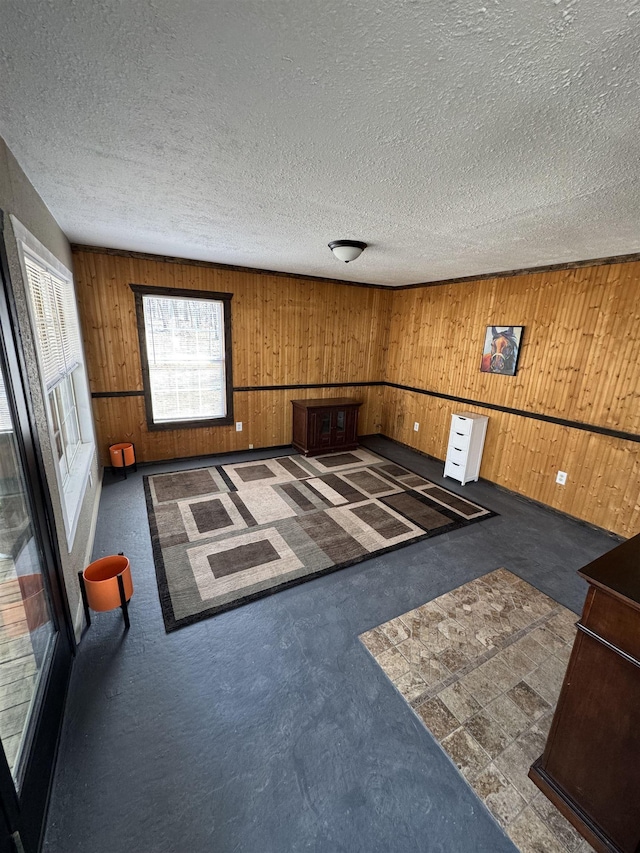 unfurnished living room with wooden walls and a textured ceiling