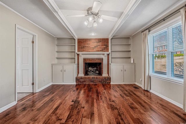 unfurnished living room featuring ceiling fan, baseboards, dark wood finished floors, built in features, and ornamental molding