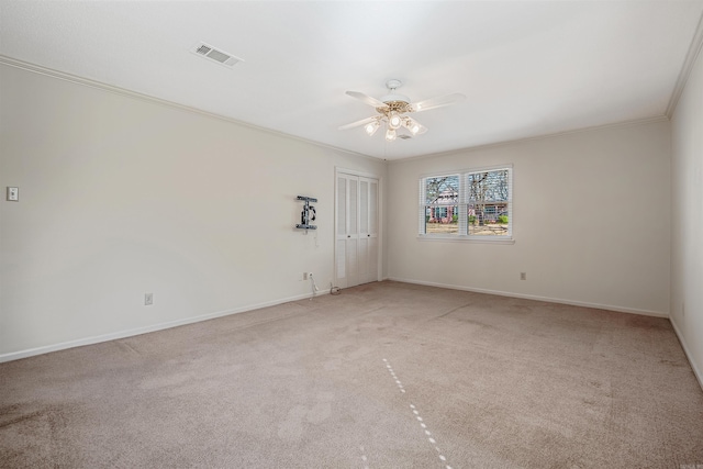 unfurnished room with visible vents, light carpet, a ceiling fan, and crown molding