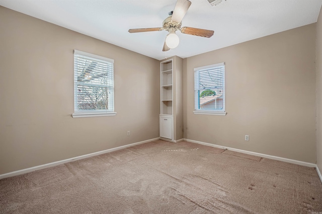 empty room with baseboards, carpet, a healthy amount of sunlight, and a ceiling fan