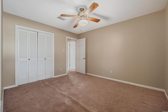 unfurnished bedroom with a closet, visible vents, baseboards, and carpet floors