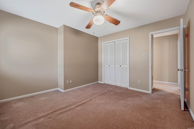 unfurnished bedroom with a closet, baseboards, carpet, and a ceiling fan