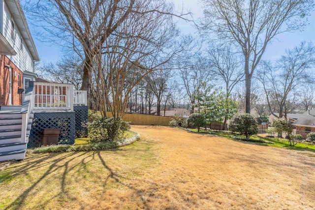 view of yard featuring a deck, stairway, and fence