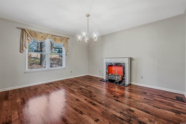 interior space with visible vents, ornamental molding, wood finished floors, baseboards, and a chandelier