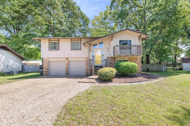 bi-level home featuring board and batten siding, fence, a front yard, central AC unit, and an attached garage