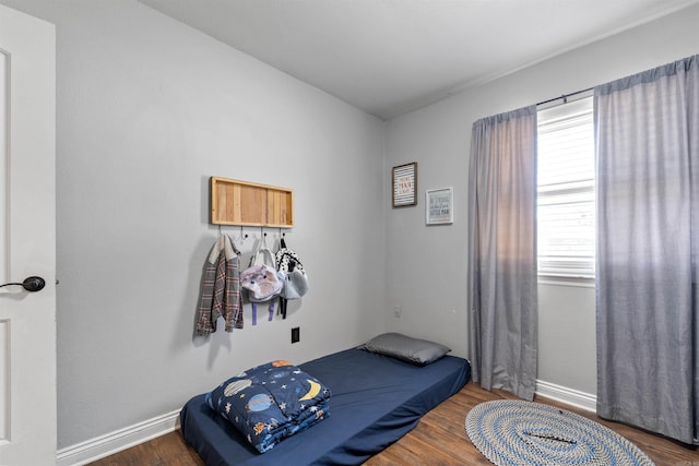 bedroom featuring baseboards and wood finished floors