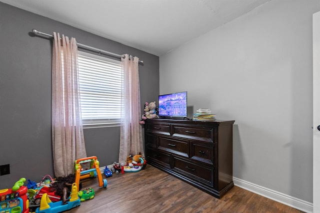 game room with dark wood finished floors and baseboards