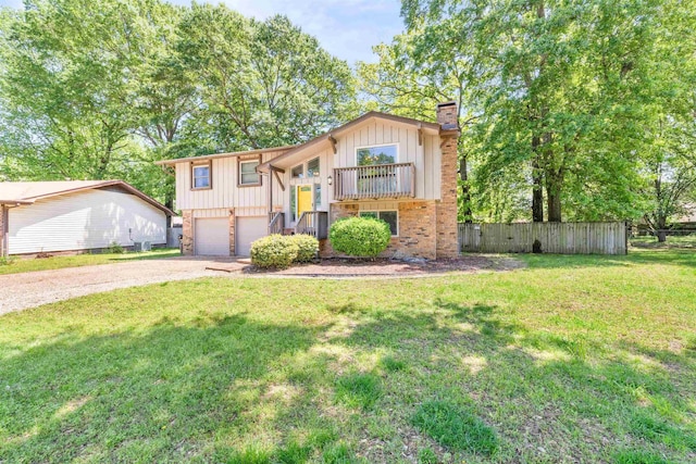 raised ranch with driveway, an attached garage, a chimney, a front lawn, and board and batten siding